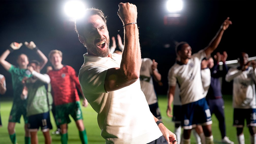 Promotional image for Dear England showing a football team celebrating with their manager in the foreground