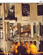 A group of men stand in front of the damaged Civil Guard barracks in Santa Pola
