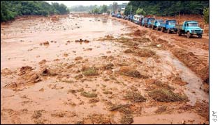 Trucks make their way down a highway washed away by landslides in Ma An Shan, in central Anhui province on Thursday