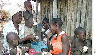 A grandmother feeds donated bread to her family in Zimbabwe