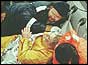 Tony Bullimore in waterproof suit, surrounded by rescuers in life raft