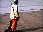 Hunter drags dead seal across beach