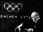 IOC President Avery Brundage with Olympic logo in background
