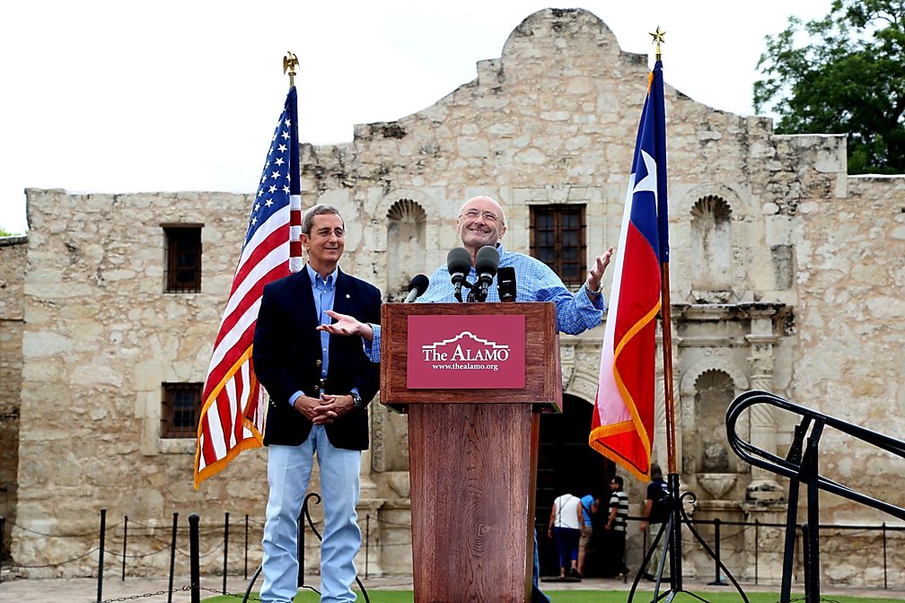 Texas Land Commissioner Jerry Patterson listens as Phil Collins speaks in front of The Alamo, announcing the donation of his collection of artefacts, 2014
