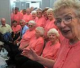 Aelodau C&ocirc;r Pontarddulais yn aros eu tro yng nghystadleuaeth y Corau Pensiynwyr