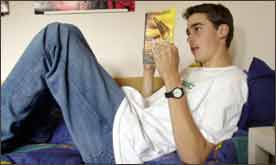 Teenage boy reading The Amber Spyglass by Phillip Pullman