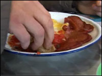 A man eating oatcakes with bacon