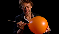 Dallas Campbell attempts to skewer a balloon.
