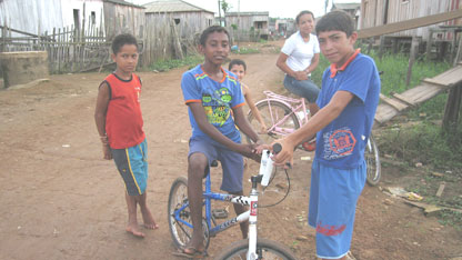 Some of the younger members of the community in front of the stilt homes