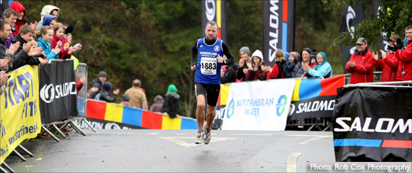 Rob Sloan crosses the finish line of the Kielder marathon to the applause of spectators