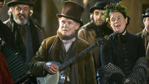 Dikensian Christmas scene featuring singers