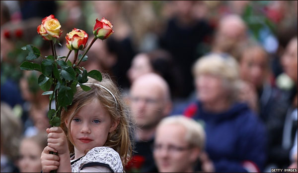 Una niña sostiene unas rosas en una vigilia en Oslo.