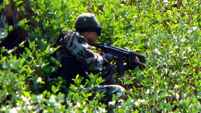 Armed gunman during a raid of an illegal coca lab in the Red Zone