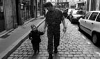 A soldier walking with a child.