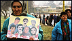 Serb woman with pictures of her family killed in Srebenica