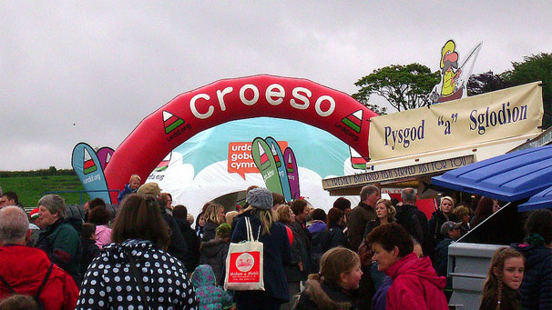 Arwydd croeso uwchben y maes