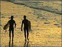 Surfers walking the beach in north Norfolk
