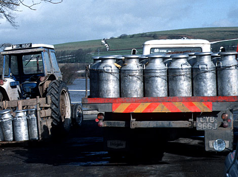 A row of milk churns loaded onto a lorry for transportation