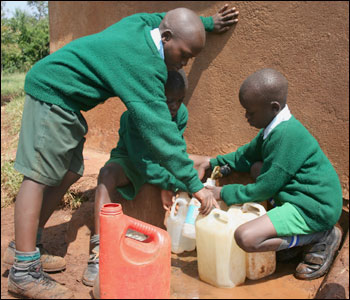three boys collecting water from stand pipe