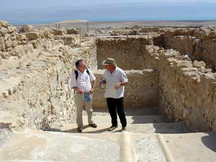 Roger Bolton (left) and Professor Hanan Eshel stand in front of a wide, deep walled stone structure that looks like a pool or trough