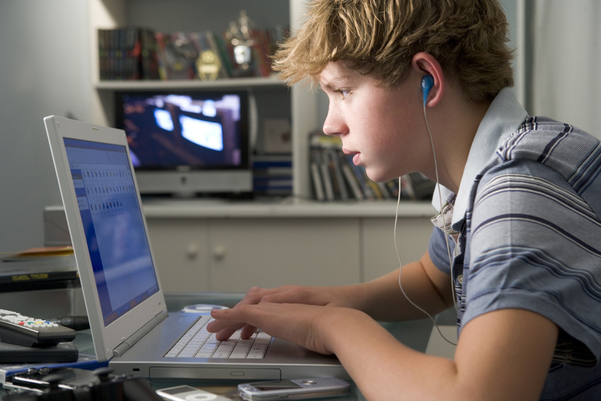 young boy using laptop and listening to MP3 player @ monkey business - fotolia