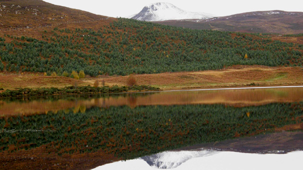 Snow-capped Ben Horn reflected in the calm waters of Loch Brora