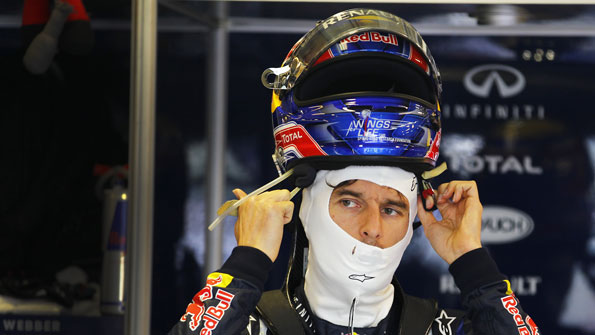 Racing car driver lifting helmet