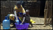 Woman washes up in a plastic bowl in Daaba village Kenya