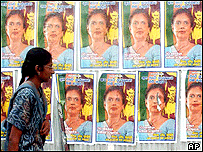Jovem olha cartazes da presidente do Sri Lanka