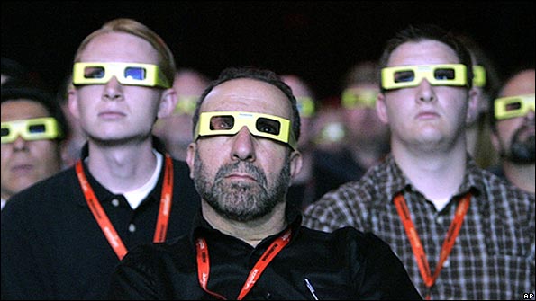 Spectators watch a large screen in 3-D spectacles