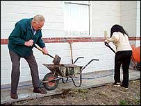 Gail and a volunteer dig in the garden