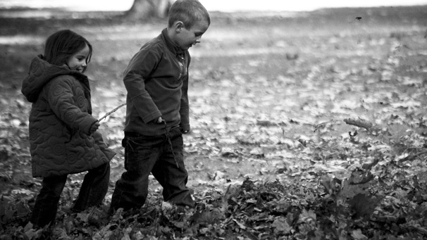 Two children playing with leaves