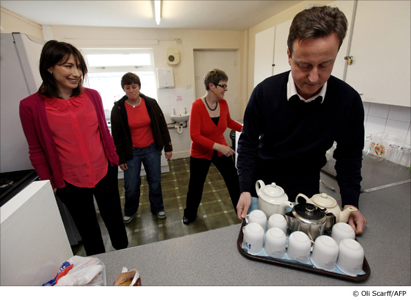 David Cameron is watched by his wife Samantha during their visit to a parenting resource centre in Halifax