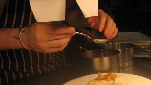 Chef spooning sauce onto a dish