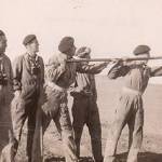 Stanley Painter and colleagues gun cleaning in Egypt 1944 - the caption on the back of the photo reads: "The lazy man is on the left"