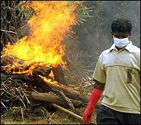 Militante do grupo Tigres do Tamil passa por pira funerária