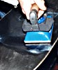 Spreading the melted wax with the waxing iron, then scraping off the excess.