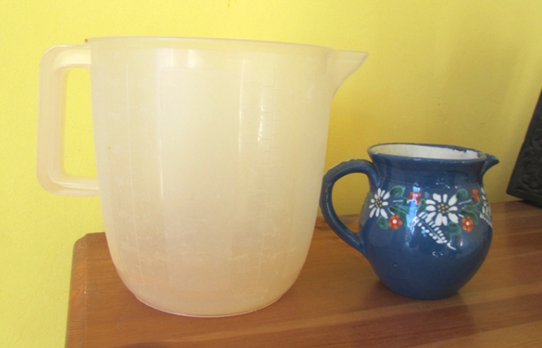 Plastic measuring jug and pottery milk jug