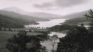 Black and white view of Loch Tummel with hills around and Schiehallion behind.