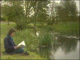 Penny Hemphill reading on the river bank