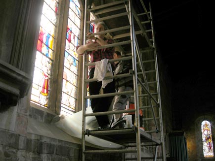 Scaffolding placed in front of the windows, as men work on removing the panels