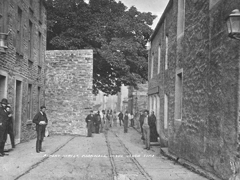 Black and white view of Albert Street, Kirkwall, showing wall surrounding the Big Tree.