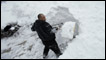 Homem retira neve de calçada na cidade de Des Moines, Iowa, nesta sexta-feira (AP) 