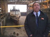 Peter Callaghan in front of a ship in a dry dock