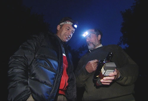 Chris with a bat expert at night