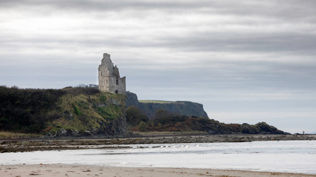 View across beach to Greenan Castle, which stands perched on a low cliff-top.
