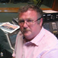 Sam in the BBC Radio Ulster studios with various medals, a banner and a bugle from his time in time in the RIR
