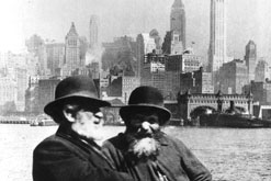Jewish immigrants at Ellis Island, with the skyscrapers of New York in the background