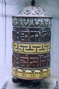 Prayer wheel, a carved and painted cylindrical drum standing upright on a central spindle
