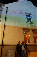 Two artists in front of a shop